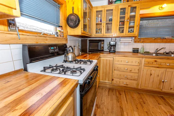 a kitchen with granite countertop a sink cabinets stainless steel appliances and a window