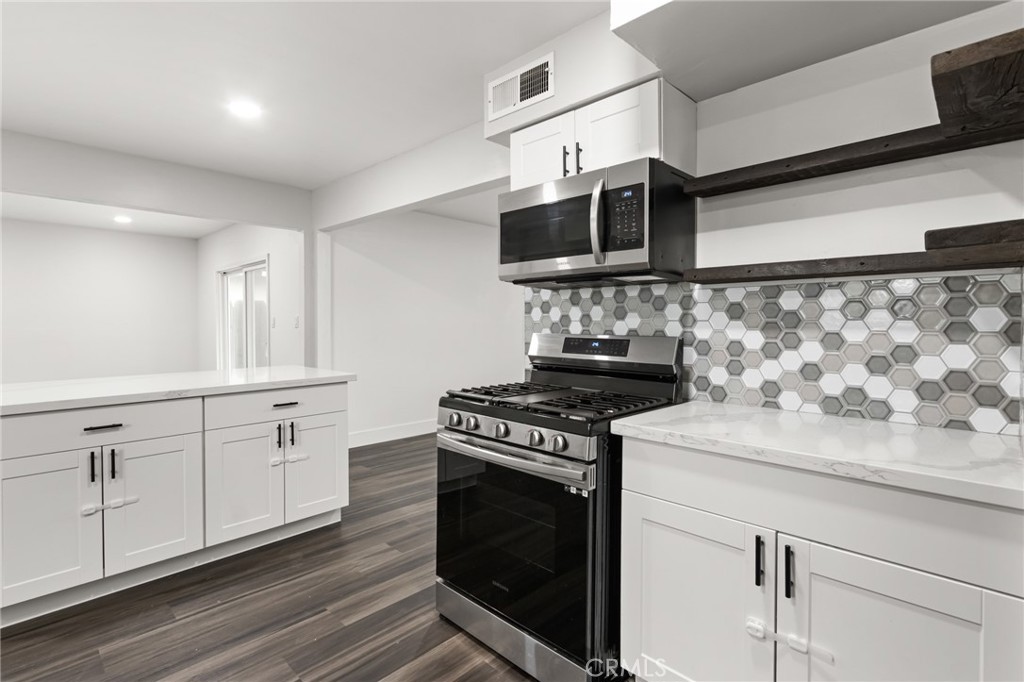 2618 Hoover Court Merced, CA 95340 - Photo 8 of 30 a kitchen with stainless steel appliances granite countertop a sink a stove and microwave