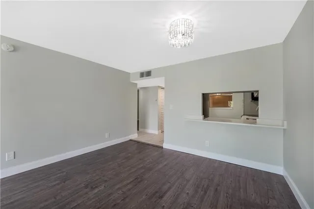 a view of a room with wooden floor and a chandelier