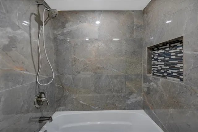 a bathroom with a shower and a bath tub