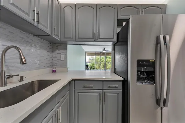 a kitchen with stainless steel appliances granite countertop a refrigerator and a sink