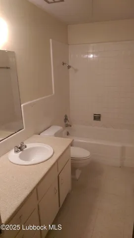 a bathroom with a granite countertop sink a toilet and shower