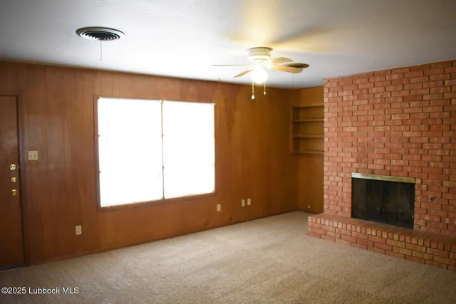 a view of empty room with window and fireplace