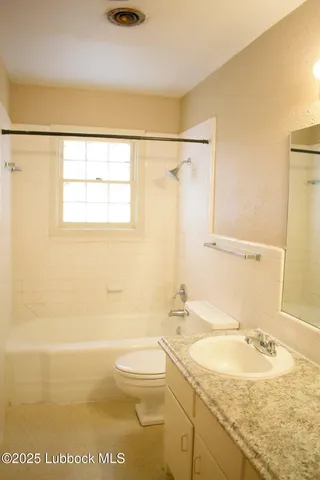 a bathroom with a granite countertop sink a toilet and shower