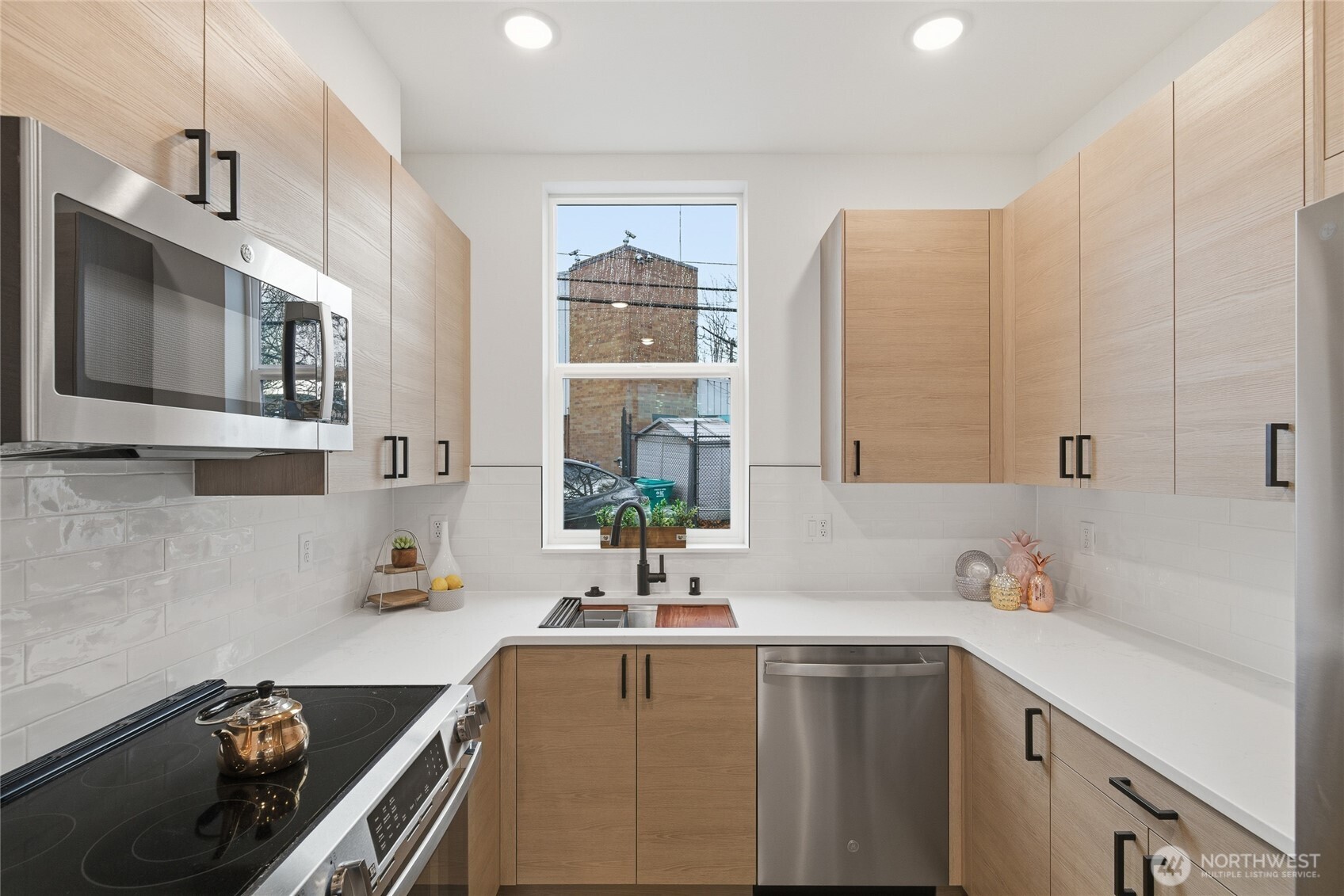 805 South Sullivan Street, Unit B Seattle, WA 98108 - Photo 10 of 20 a kitchen with stainless steel appliances a sink a stove and white cabinets