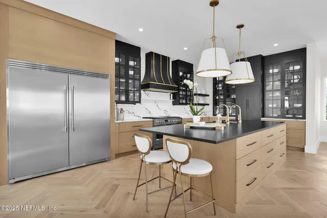 a large white kitchen with a sink and a stove top oven