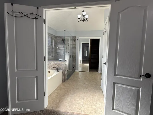 a spacious bathroom with a glass shower door and a bathtub