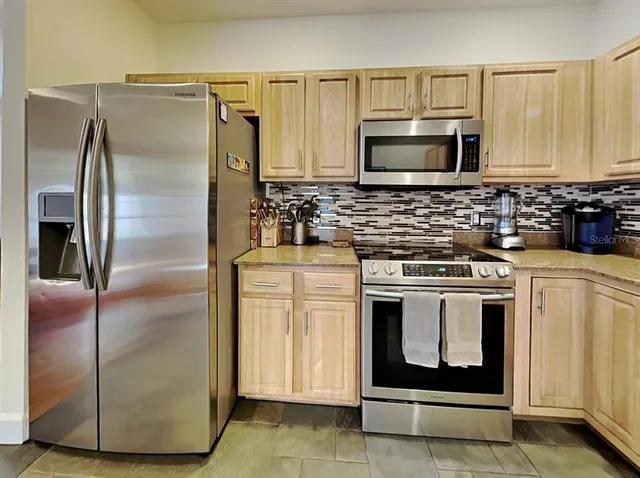 a kitchen with stainless steel appliances granite countertop white cabinets sink and granite counter top