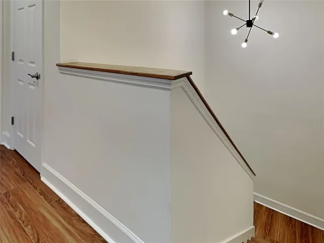 a view of a livingroom with wooden floor a fireplace and entryway
