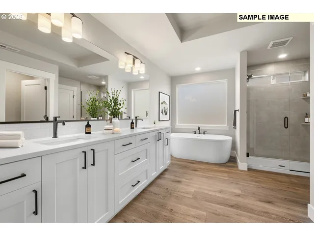 a spacious bathroom with a double vanity sink a mirror and a bathtub