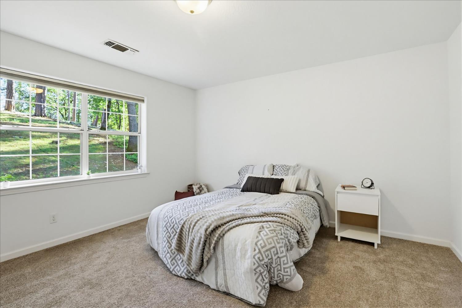 21324 Oak Ridge Drive Grass Valley, CA 95945 - Photo 20 of 32 a bedroom with a bed and next to a window