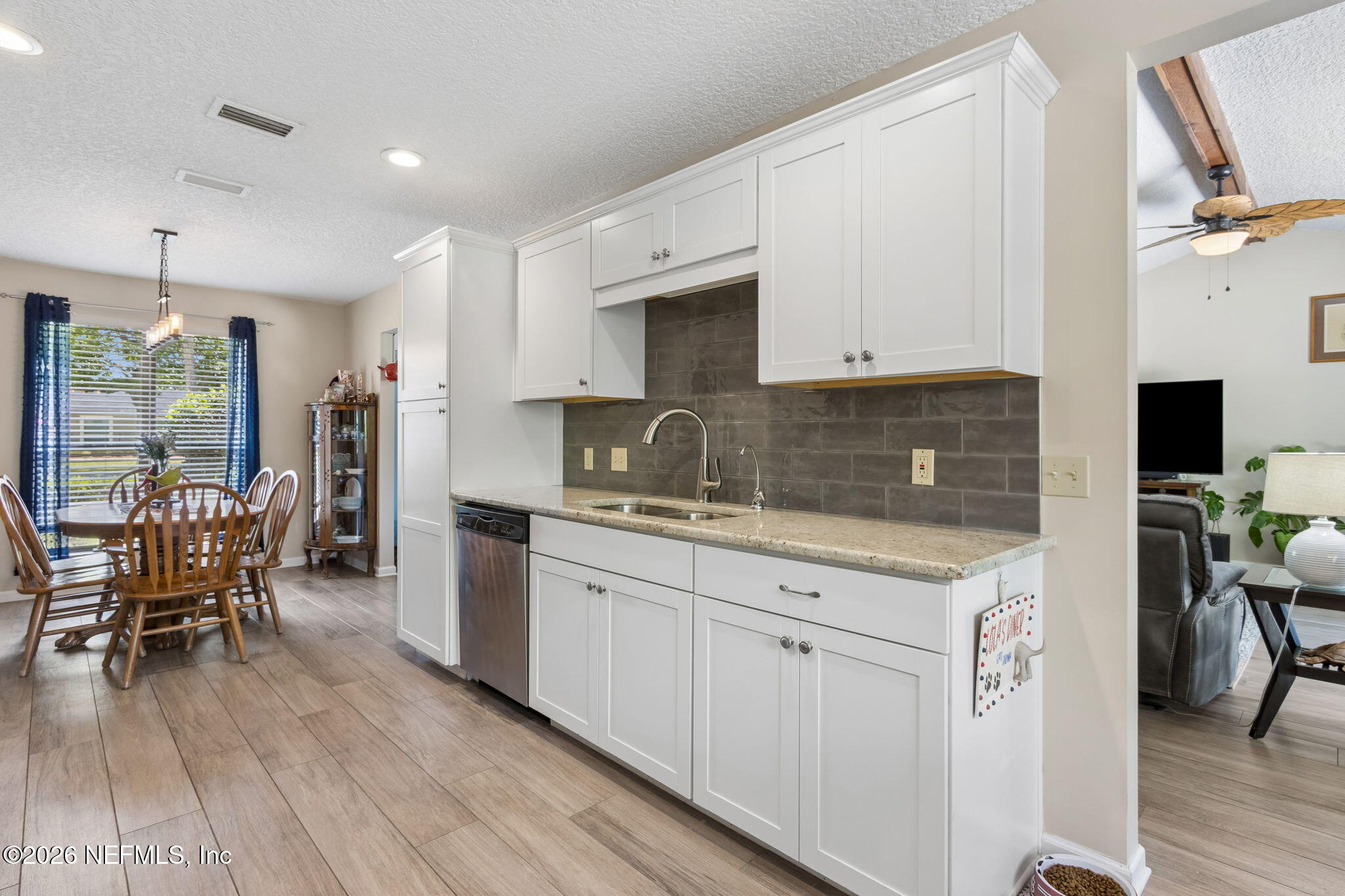 3194 Creighton Landing Road Fleming Island, FL 32003 - Photo 16 of 31 a kitchen with granite countertop a dining table chairs refrigerator and sink