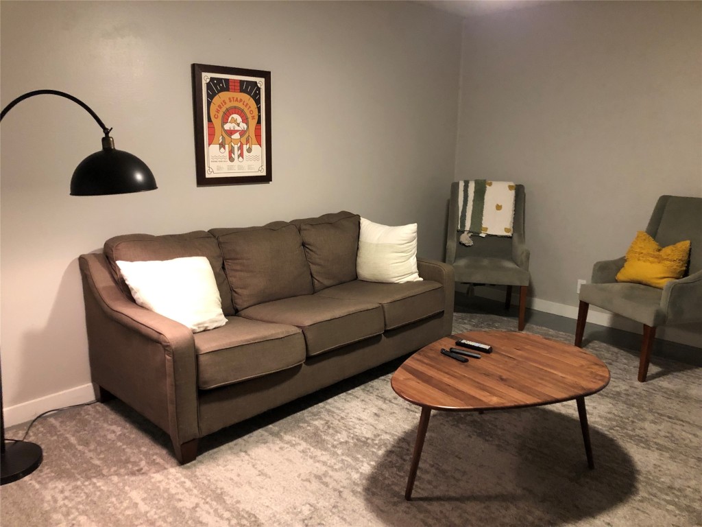 a living room with furniture a rug and a wall painting