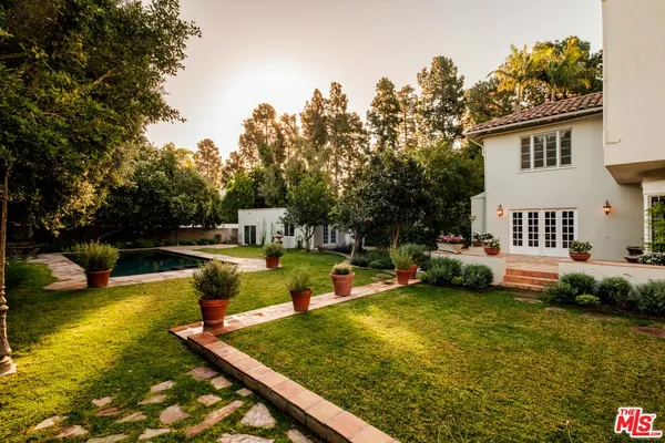 a swimming pool with outdoor seating and plants