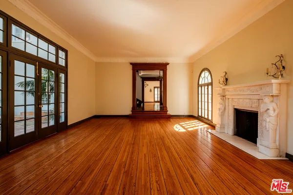 a view of a room with wooden floor and chandelier