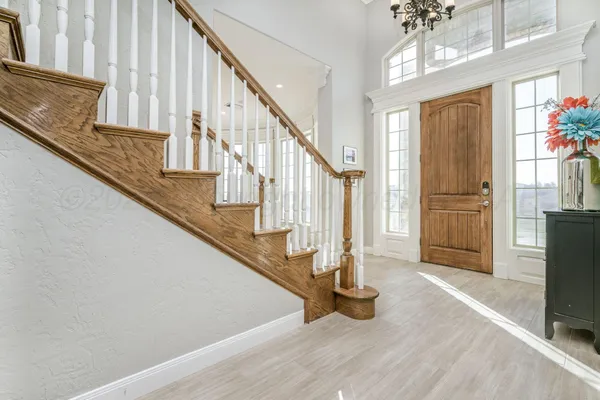 a view of a hallway with entryway wooden floor and windows