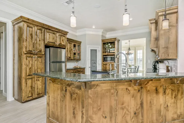 a kitchen with stainless steel appliances granite countertop wooden floors and granite counter tops