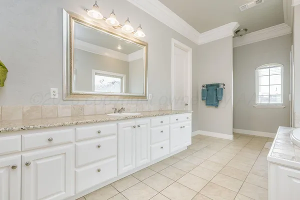 a bathroom with a granite countertop sink mirror and window