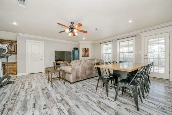 a living room with furniture gym equipment and a ceiling fan