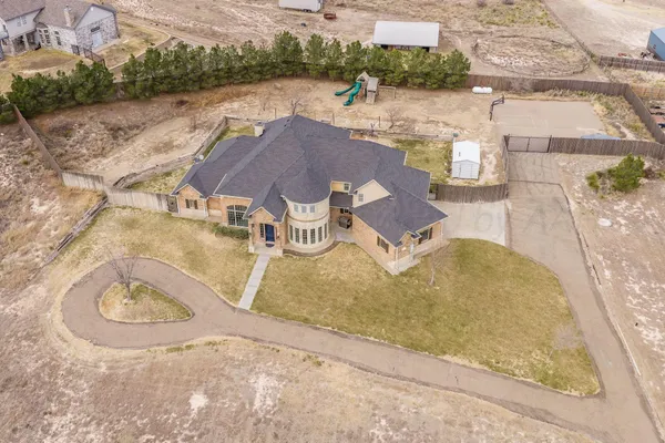 an aerial view of a house with a yard and lake view