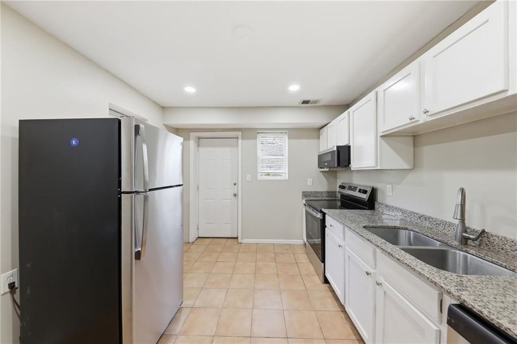 94 Ericson Street Southeast Atlanta, GA 30317 - Photo 8 of 39 a kitchen with granite countertop a refrigerator and a sink