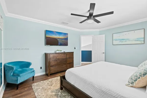 a bedroom with a bed a couch and a flat screen tv