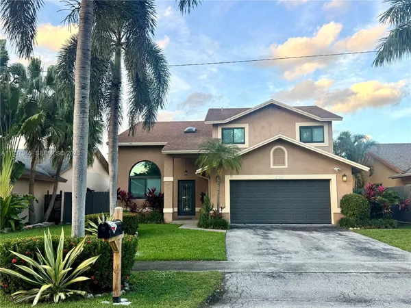a front view of a house with a garden and plants