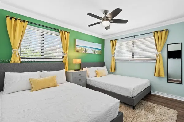 a bedroom with two beds and a large window