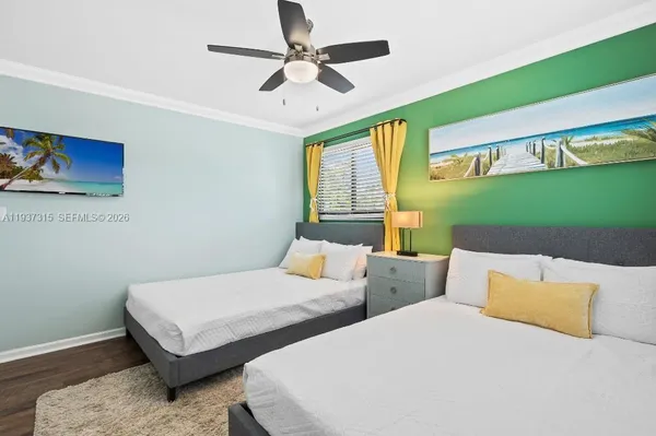 a bedroom with two beds and a ceiling fan