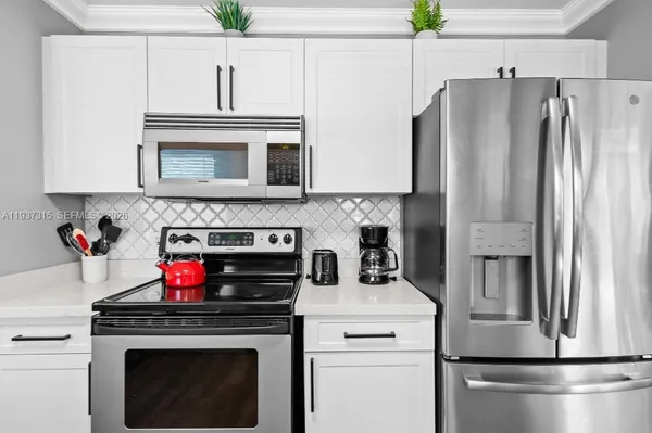 a kitchen with appliances a refrigerator and cabinets
