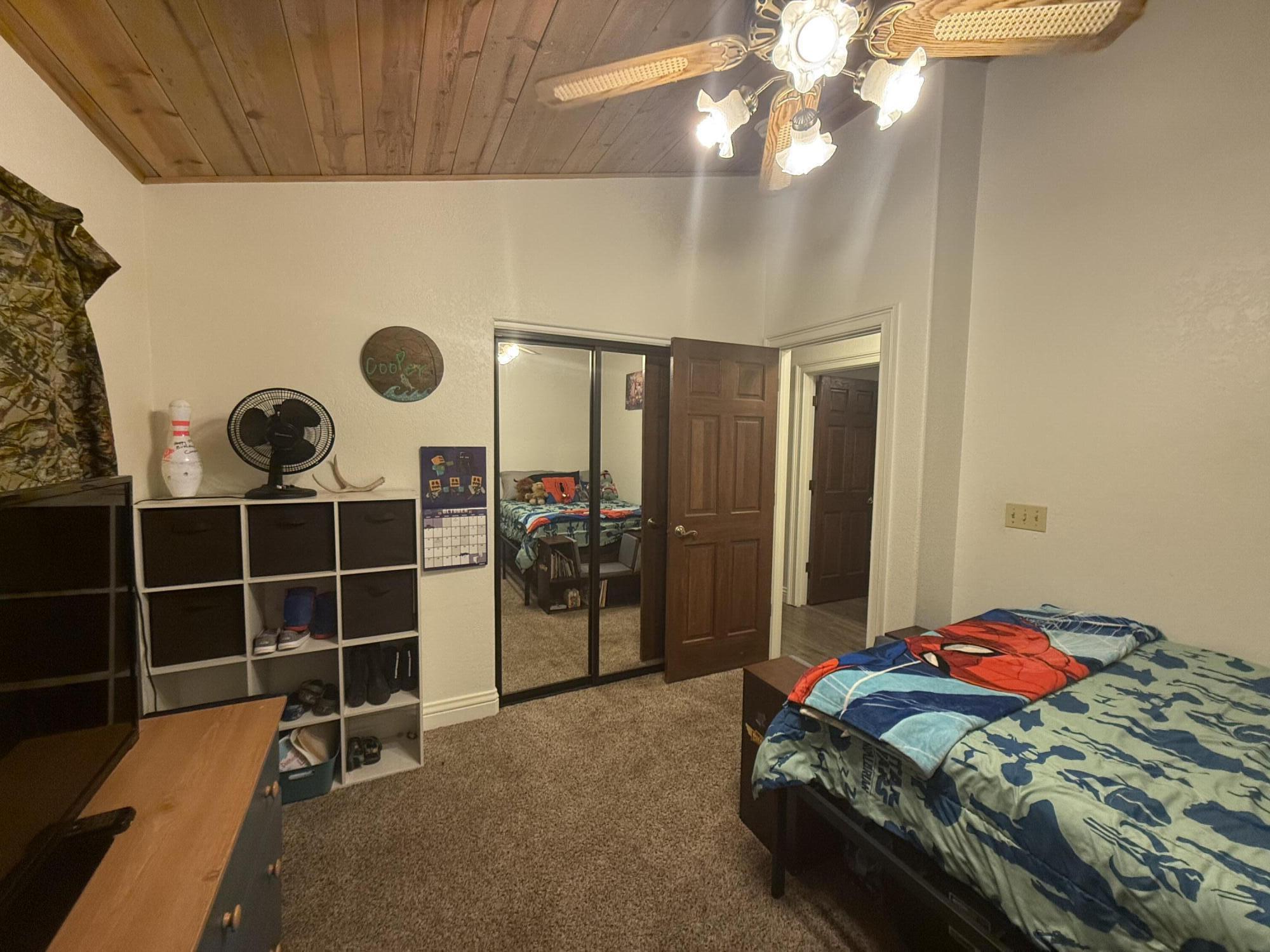 7097 Shasta Forest Drive Shingletown, CA 96088 - Photo 18 of 44 a bedroom with a bed and a chandelier