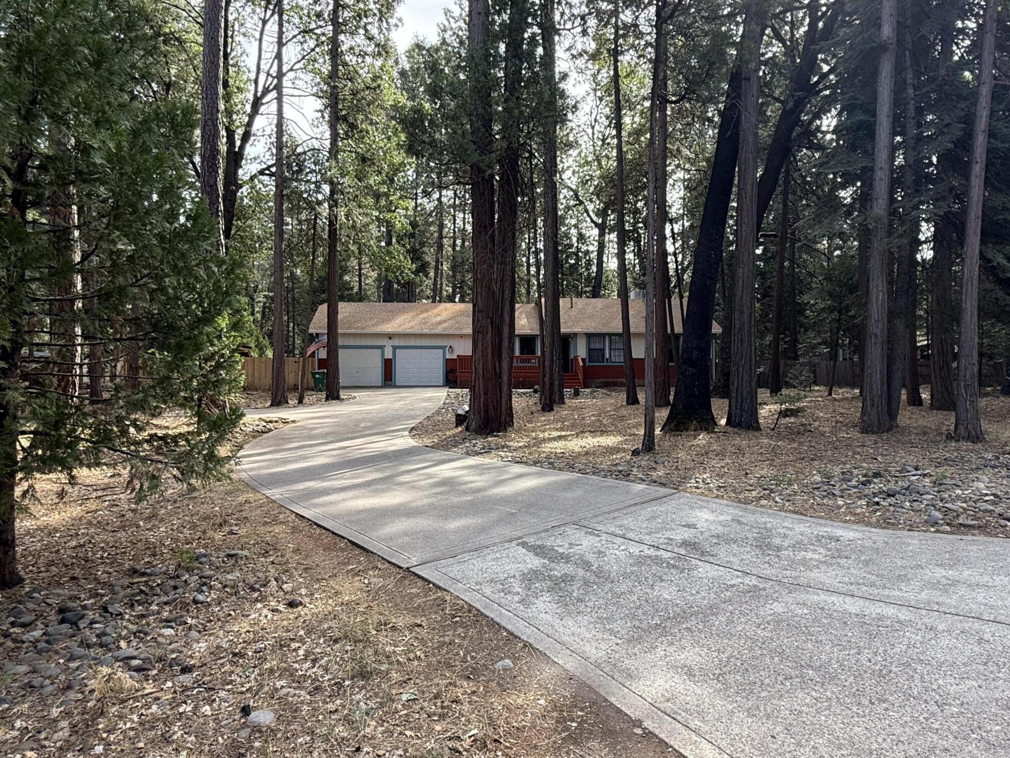 7097 Shasta Forest Drive Shingletown, CA 96088 - Photo 4 of 44 a view of a white house with a large tree