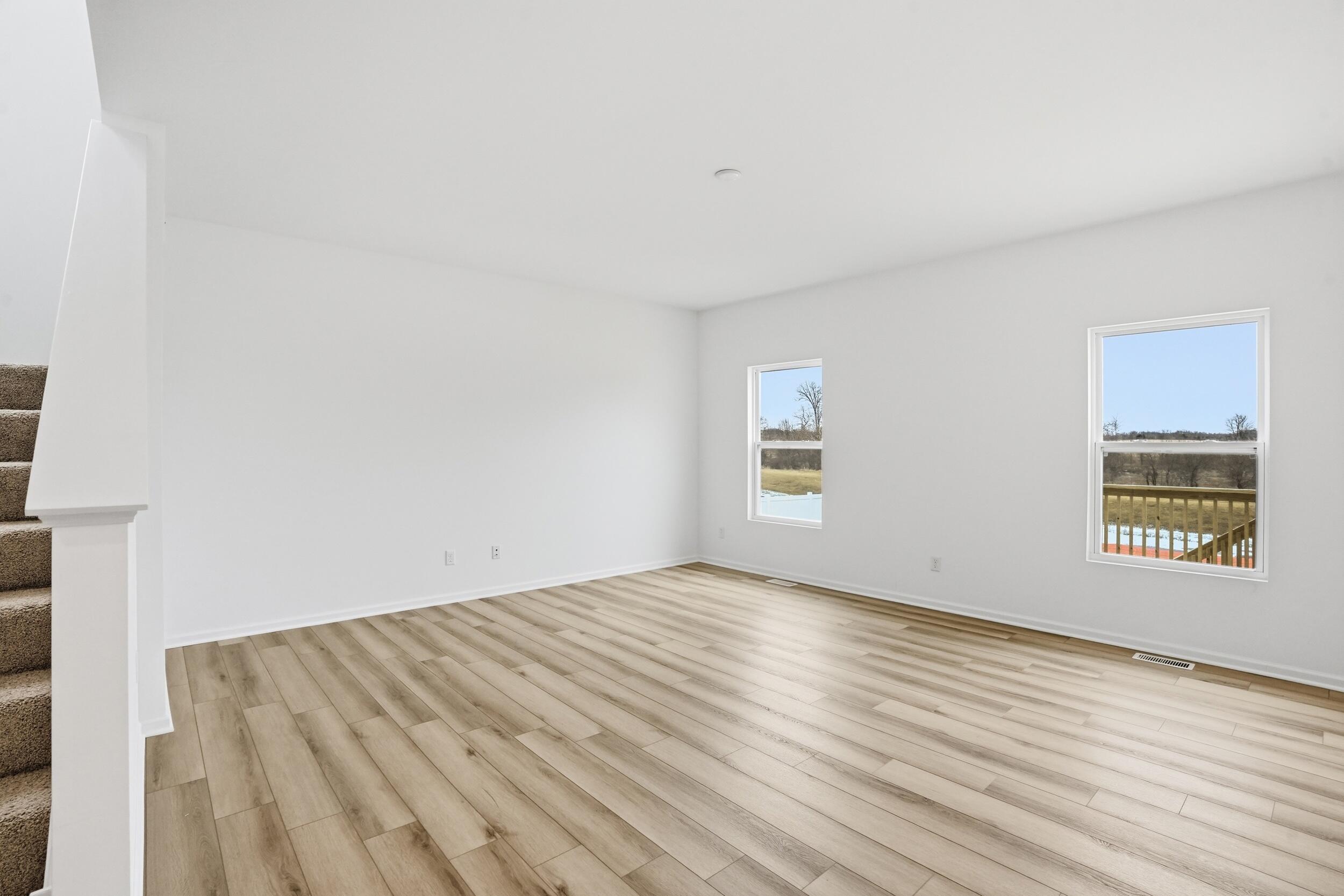 6587 East 104th Avenue Winfield, IN 46307 - Photo 14 of 34 a view of an empty room with wooden floor and a window