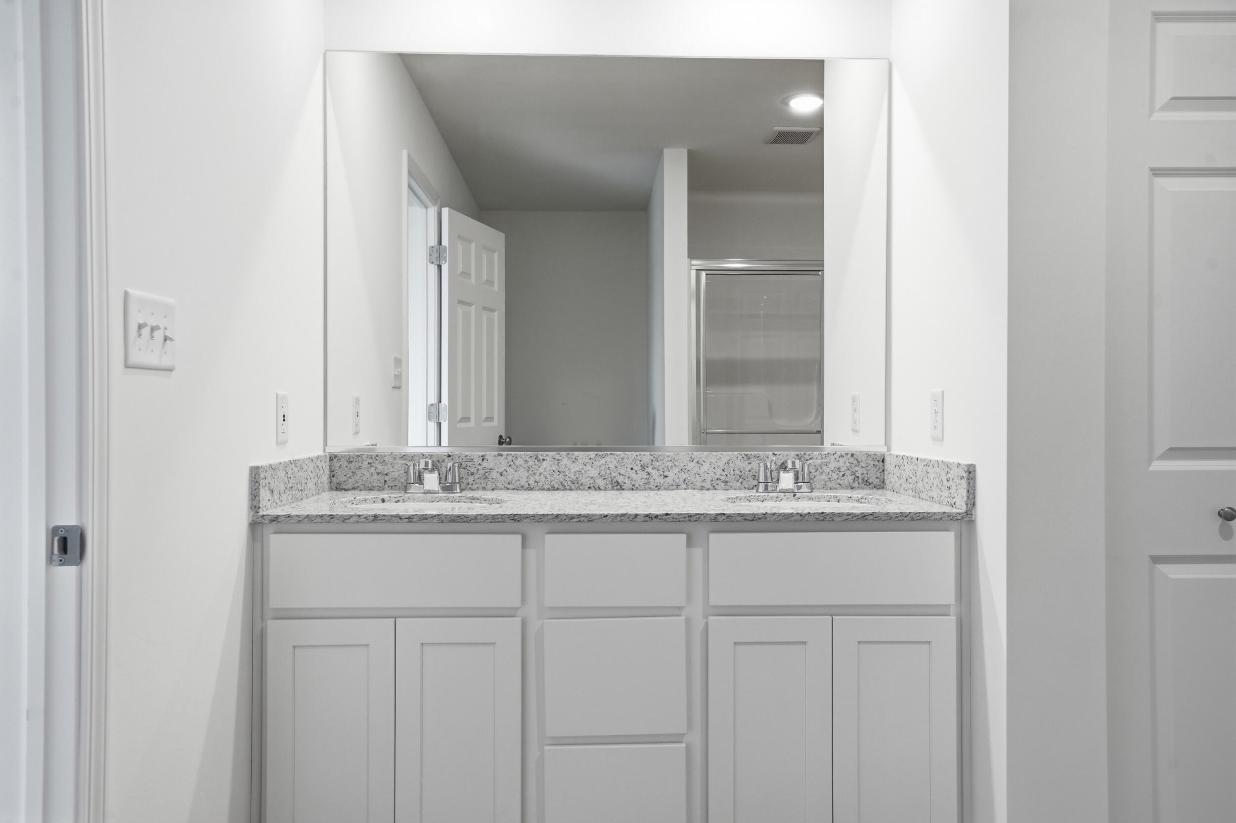 6587 East 104th Avenue Winfield, IN 46307 - Photo 21 of 34 a bathroom with a granite countertop sink and a mirror