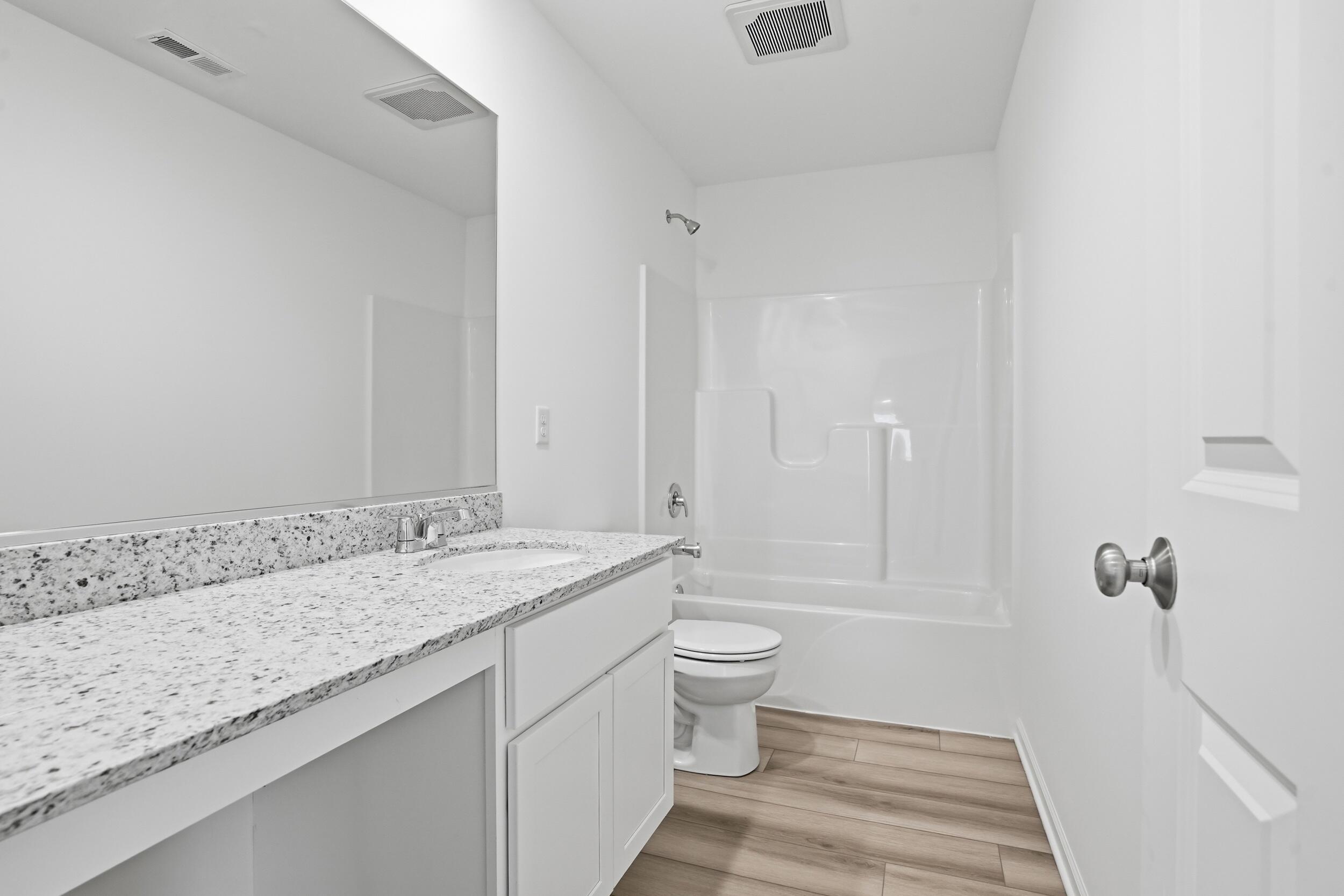 6587 East 104th Avenue Winfield, IN 46307 - Photo 28 of 34 a bathroom with a granite countertop sink a toilet and shower