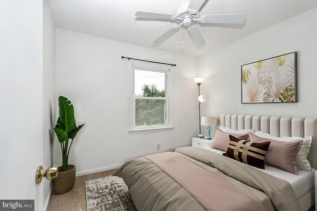 a bedroom with bed a chandelier and a window