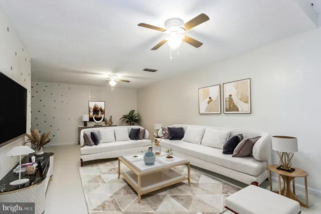 a living room with furniture a rug and a flat screen tv