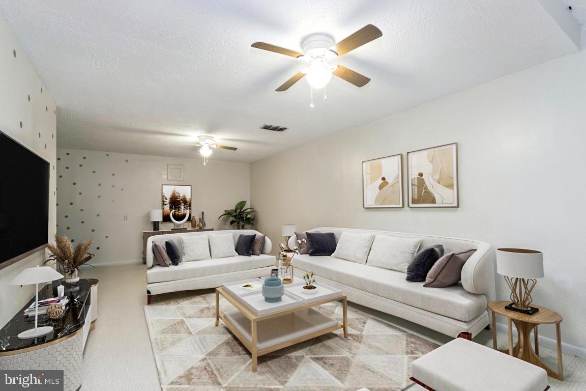 611 Madison Court, Unit 611 Stafford, VA 22556 - Photo 7 of 13 a living room with furniture a rug and a flat screen tv