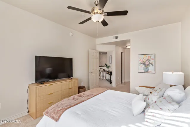 a bedroom with a bed tv and a chandelier