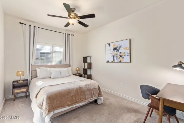 a bedroom with a bed a chair and a large window