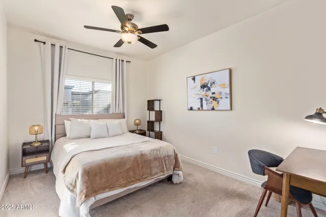 a bedroom with a bed a chair and a large window