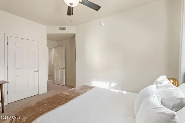 a bedroom with a bed and a chandelier fan
