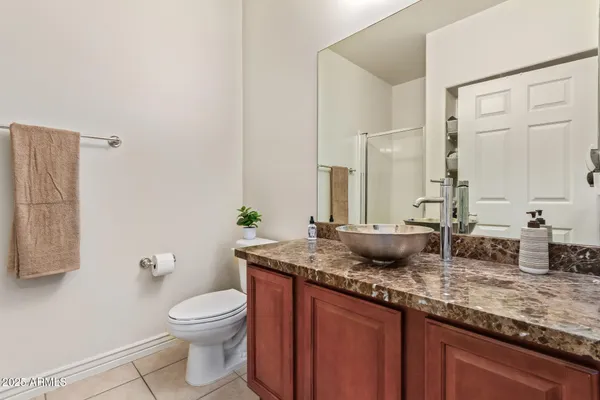 a bathroom with a granite countertop sink a toilet and a mirror
