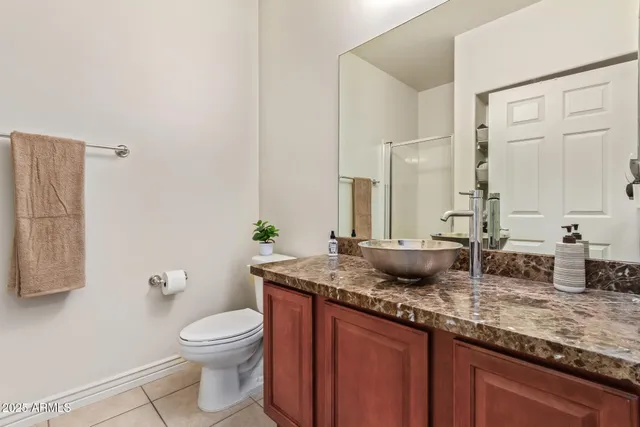 a bathroom with a granite countertop sink a toilet and a mirror
