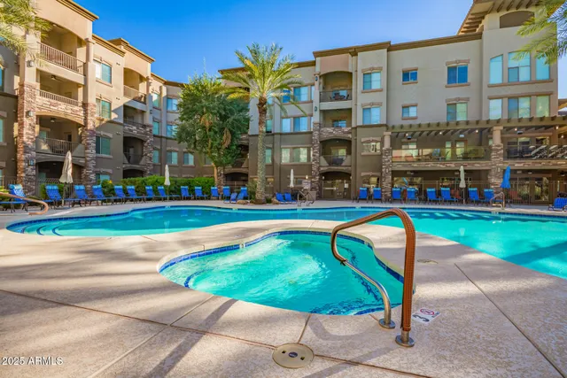 a view of a swimming pool with a bench in front of building
