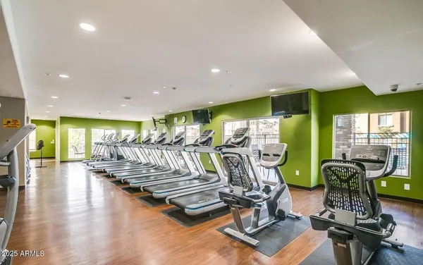 a living room with furniture a wooden floor and gym equipment
