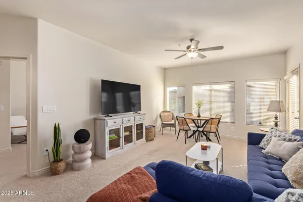 a living room with furniture a flat screen tv and a large window