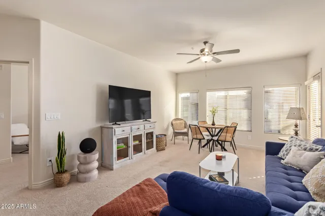 a living room with furniture a flat screen tv and a large window