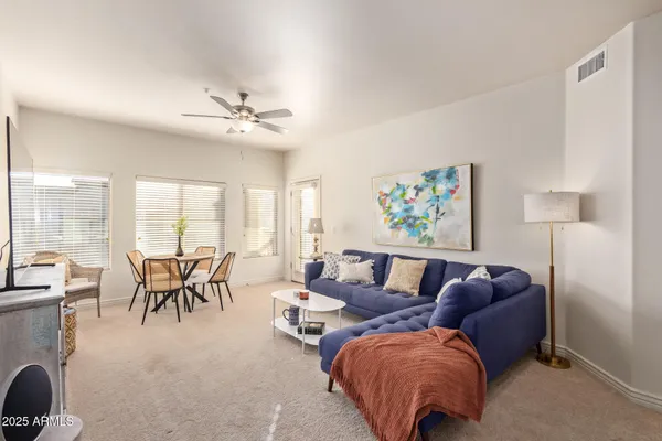 a living room with furniture a large window and a chandelier