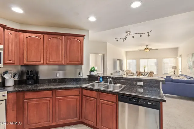 a kitchen with granite countertop a sink stainless steel appliances and cabinets